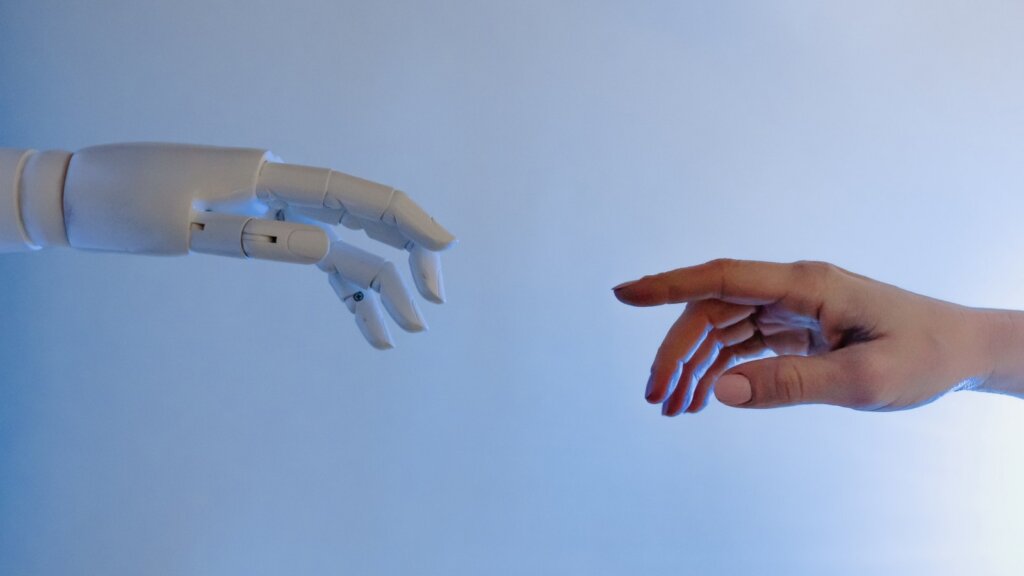 robot arm and human arm going to touch