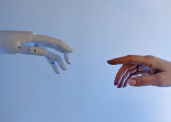 robot arm and human arm going to touch